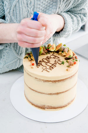 Close up of Luminary Bakery birthday cake being iced.