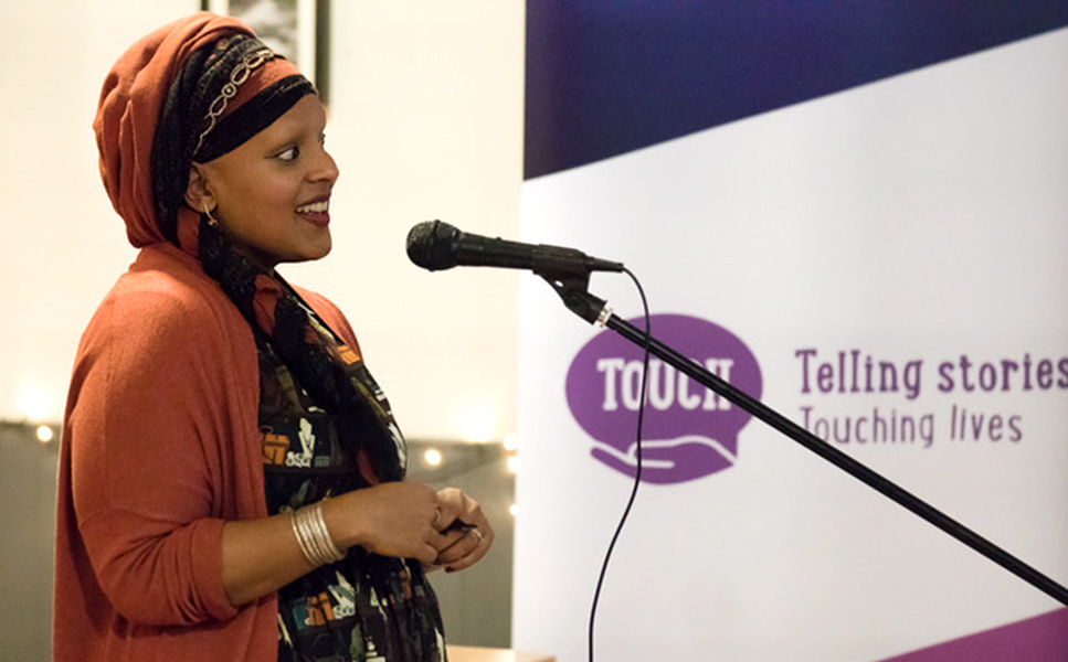 Woman speaking at Microphone at the Touch Network If Trust